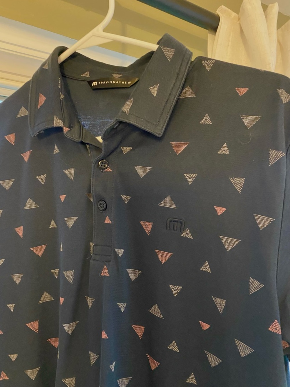 Travis Mathew Navy Polo with Pink & White Triangle Pattern